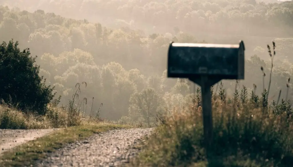 A narrow country road through Western Pennsylvania hills in early morning fog.